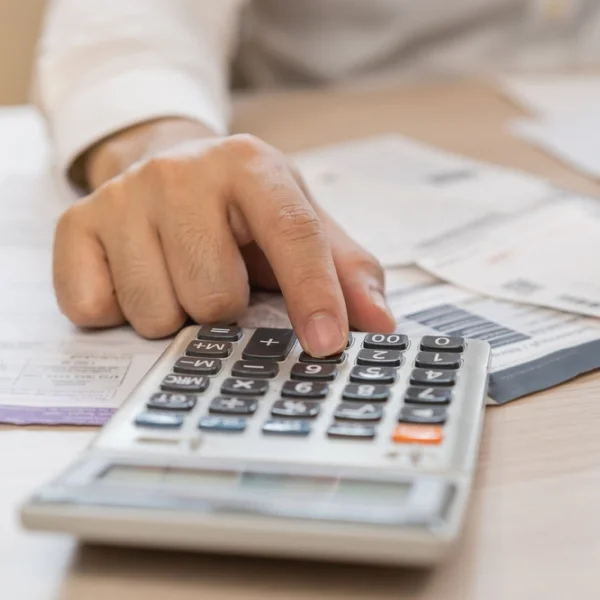 A person calculating money using a calculator, focused on determining an amount for an instant loan.