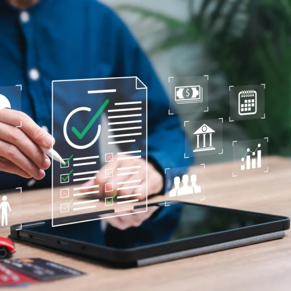 Un homme d'affaires examine une tablette affichant des icônes relatives aux prêts pour mauvais crédit, symbolisant des solutions et des options financières.