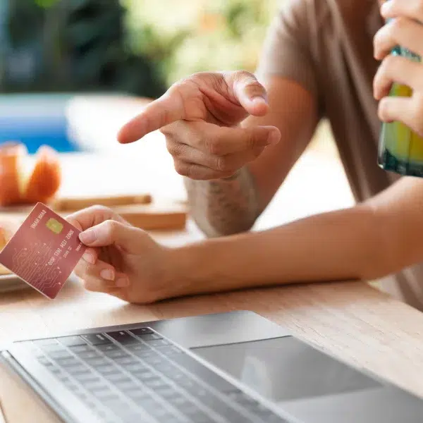 Un homme et une femme assis à une table, utilisant un ordinateur portable pour discuter de crédits personnalisés.