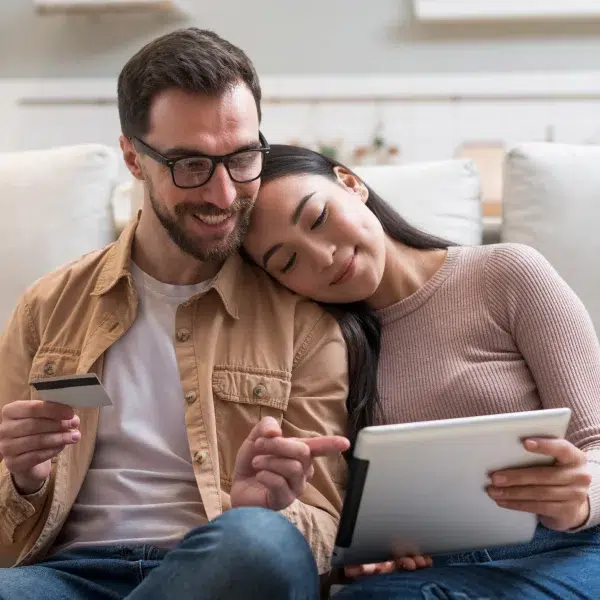 Un couple utilise une tablette et une carte de crédit à la maison pour un crédit personnalisé.