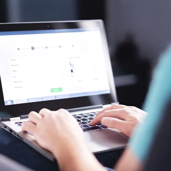 A person typing on a laptop computer.