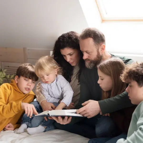 Une famille lisant un livre ensemble, partageant un moment de convivialité et d'apprentissage.