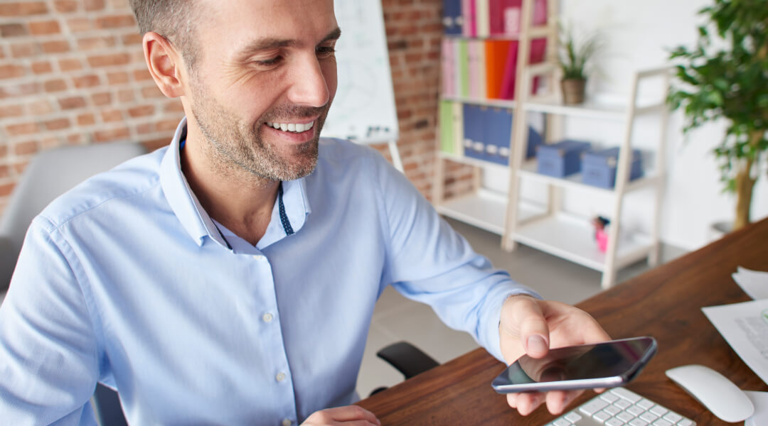 Smiling man using smartphone for personalized online loan financing solution