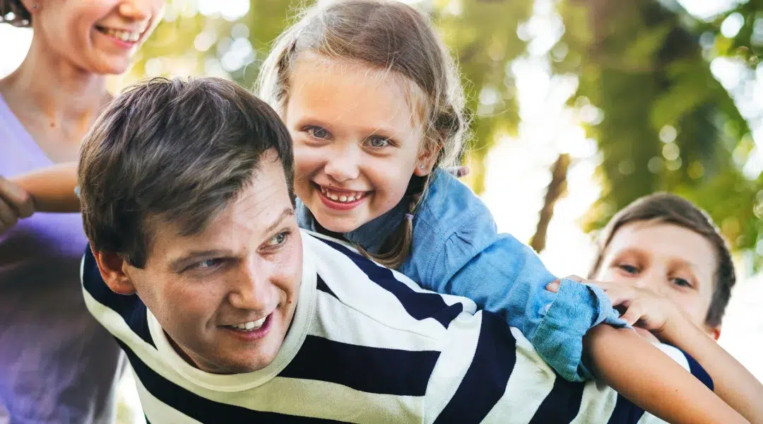 Une famille souriante s'amuse ensemble, partageant des moments joyeux et chaleureux.